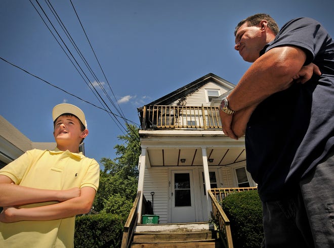 Stephen Donnelly Jr., 11, talks about the 911 call he made as his father, Stephen Donnelly, right, entered a burning house on Tremont Street in Braintree to help residents get out. The photo was taken on Thursday, July 12, 2012, the day after the fire.
