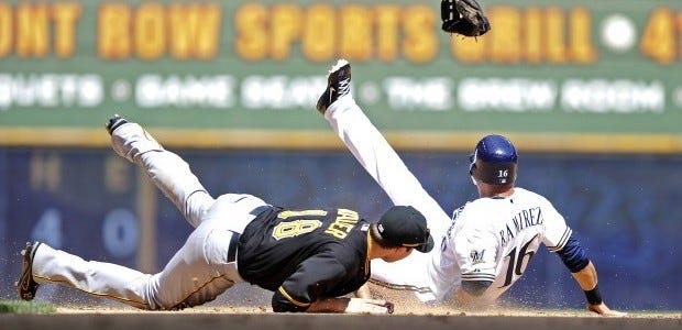 Pittsburgh Pirates' Neil Walker (18) gets his glove kicked out of his hand by Milwaukee Brewers' Aramis Ramirez as he steals second base during the sixth inning of a baseball game Sunday in Milwaukee. The Brewers beat the Pirates, 4-1.