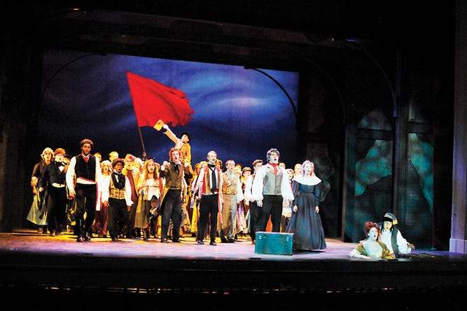 Jean Valjean (Jonathan Crayne) and Cosette (Charlotte Darr), standing in the foreground, lead the Parisian students, residents, and Thenardier and his wife (Victor Tran and Maddie Montambault), arising from the “sewers,” in “One Day More” in the Croswell Opera House’s production of “Les Miserables, Student Edition.”