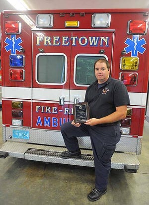 Firefighter Wesley Vaughan, Freetown’s Emergency Management Agency director, poses with a plaque honoring him as the state’s EMA director of the year, in August 2010.