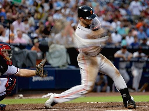 In this image using a slow shutter speed, San Francisco Giants' Buster Posey hits a double to score three runs in the fourth inning of a baseball game against the Atlanta Braves, Tuesday, July 17, 2012, in Atlanta. (AP Photo/David Goldman)