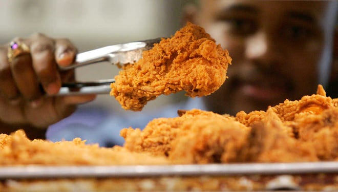 A Kentucky Fried Chicken employee uses tongs in 2006 to hold a sample of the company's trans fat-free extra crispy fried chicken in New York. New York City now has hard evidence that its ban on trans fat in restaurant food made a meaningful dent in people's consumption of the artery clogger and wasn't just replaced with another bad fat. The findings, published Monday, have implications beyond heart health, suggesting another strategy to curb the nation's obesity epidemic fueled by a high-calorie, super-sized environment.