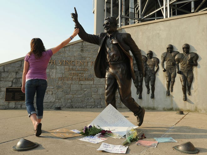 Kim Ranck touches the arm on the Joe Paterno statue as she walks away in tears Wednesday, July 18, 2012. Ranck, a 2006 Penn State University graduate and current Penn State employee, was out of town when the controversy surrounding the statue broke and came to visit before something happened to it. The Joe Paterno statue, on the Penn State campus, in State College, Pa., has become a highly debated topic since the release of the Louis Freeh report. (AP Photo/Centre Daily Times, Nabil K. Mark)