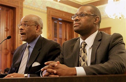 Attorney Victor Henderson, left, and Illinois Rep. Derrick Smith, D-Chicago, right, attend a legislative committee hearing investigating whether Smith should be disciplined over a bribery charge at the Illinois State Capitol Thursday, May 10, 2012 in Springfield, Ill. Smith refused to answer the legislative panel's questions, but he insisted he is innocent. (AP Photo/Seth Perlman)