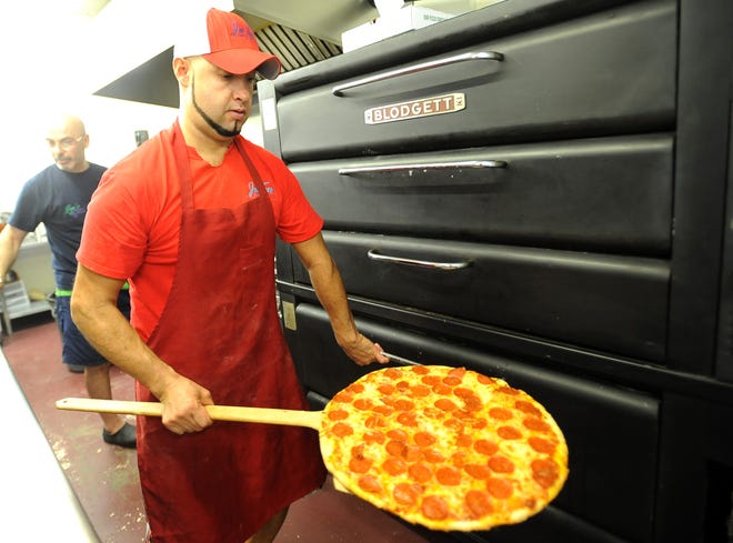 Franco Sanchez pulls a pizza from an oven at Joe's Pizza & Pasta in Bushland.