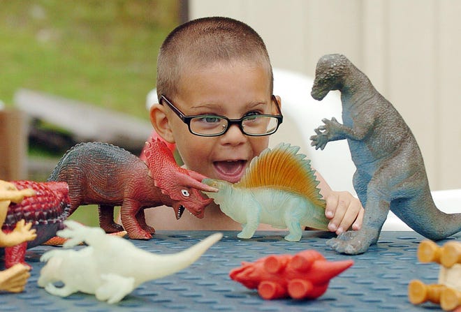 Isaias Bumpus, a preschool student at Norwich Family Resource Center, plays with dinosaurs.