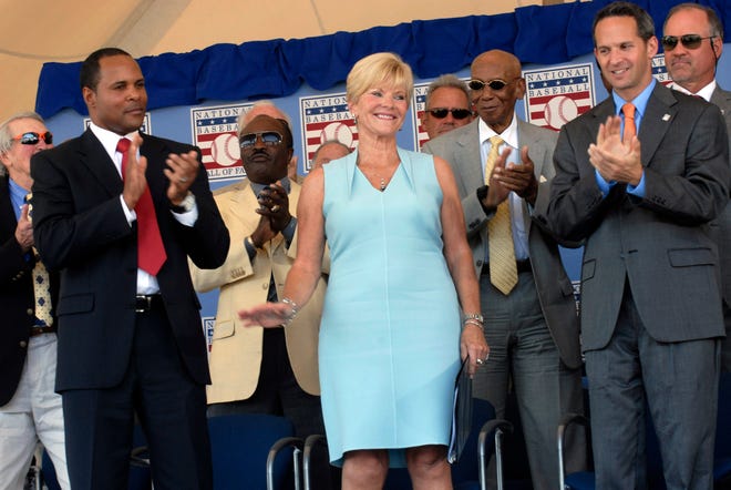 Vicki Santo, center, widow of star Chicago Cubs third baseman and team broadcaster Ron Santo, is applauded after her speech at the National Baseball Hall of Fame and Museum induction ceremony in Cooperstown, N.Y., on Sunday. At left is former Cincinnati Reds star and inductee Barry Larkin and at right is Hall of Fame president Jeff Idelson.