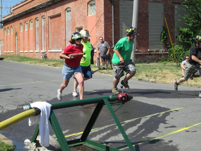 Members of the Oriskany Fire Department participate in Firematics, a sports competition, Sunday on Sauquoit Street, in New York Mills, at the 119th Annual Central New York Firemen's Association Convention.