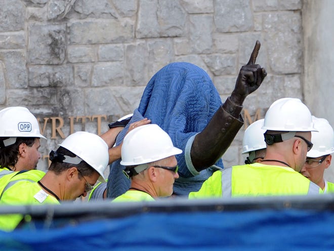 Penn State Office of Physical Plant workers cover the statue of former football coach Joe Paterno near Beaver Stadium on Penn State's campus in State College, Pa., on Sunday, July 22, 2012. The university announced earlier Sunday that it was taking down the monument in the wake of an investigative report that found the late coach and three other top Penn State administrators concealed sex abuse claims against retired assistant coach Jerry Sandusky. (The Associated Press)