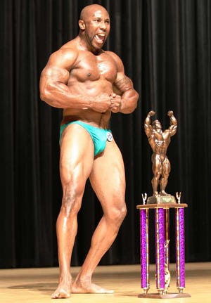 Robert Anderson poses with his trophy after winning the overall masters category at the Ancient City Classic bodybuilding competition.