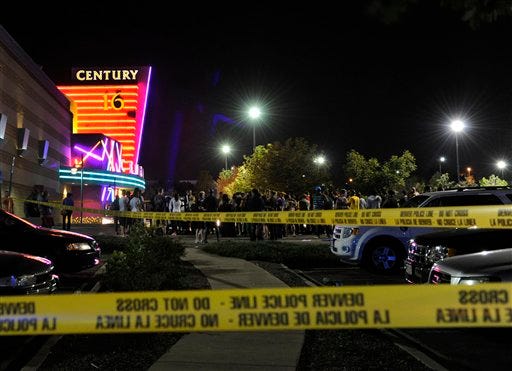 People gather outside the Century 16 movie theatre in Aurora, Colo., at the scene of a mass shooting early Friday morning, July 20, 2012. Police Chief Dan Oates says 14 people are dead following the shooting at the suburban Denver movie theater. He says 50 others were injured when gunfire erupted early Friday at the Aurora theater. Oates says a gunman appeared at the front of one of the Century 16 theaters. (AP Photo/The Denver Post, Karl Gehring)
