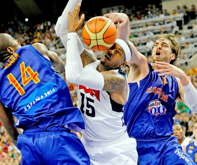 Carmelo Anthony of the US Men's Senior National Team, center, dives for the ball against Serge Ibaka of the Spain Men's Senior National Team, left, and Pau Gasol during an exhibition match between Spain and the United States Tuesday, July 24, 2012, in Barcelona, Spain, in preparation for the 2012 Summer Olympics. (AP Photo/Manu Fernandez)