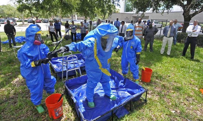 Instructor Danny Cummings (center) explains a training scenario to students as they learn decontamination techniques at Florida State College at Jacksonville's downtown campus. The Environmental Workforce Development and Job Training class includes veterans and wounded warriors.