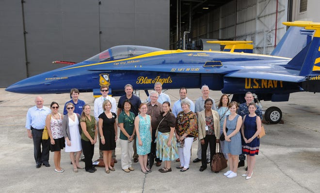 During a tour of Fleet Readiness Center Southeast (FRCSE) on July 20, members of Jax Chamber gather with Capt. Rob Caldwell (second row, right), FRCSE commanding officer, before an F/A-18 Blue Angel Hornet, a strike fighter aircraft flown by the Navy's flight demonstration squadron to enhance recruiting efforts.