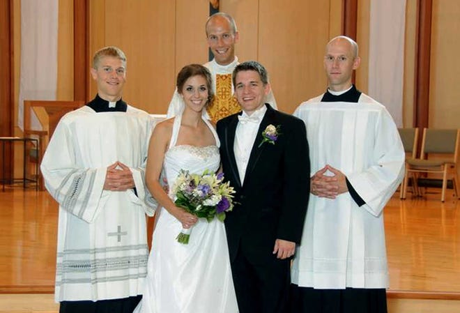 A July 23, 2011, photo provided by Bernadette Strand shows Father Luke Strand, center, after marrying sister Theresa and Christopher Krausert in Dousman, Wis. Also shown is Jacob Strand, left, and Vincent Strand, right.  (AP Photo/Courtesy Strand Family)