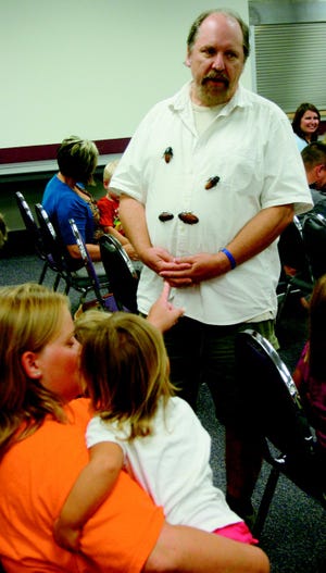 Animal Encounters’ Larry Grudt of Lansing shows off a few Madagascar cockroaches during an “Animals Around the World” presentation at the Cheboygan Area Public Library on Wednesday.