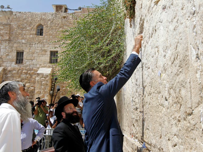Republican presidential candidate and former Massachusetts Gov. Mitt Romney places a prayer note as he visits the Western Wall in Jerusalem, Sunday. (AP)
