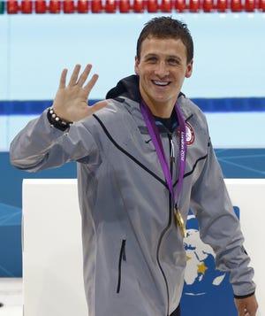 U.S. swimmer Ryan Lochte wears his gold medal as he waves to spectators after the medal ceremony for men's 400-meter individual medley swimming final at the 2012 Summer Olympics, Saturday, July 28, 2012, in London. ()