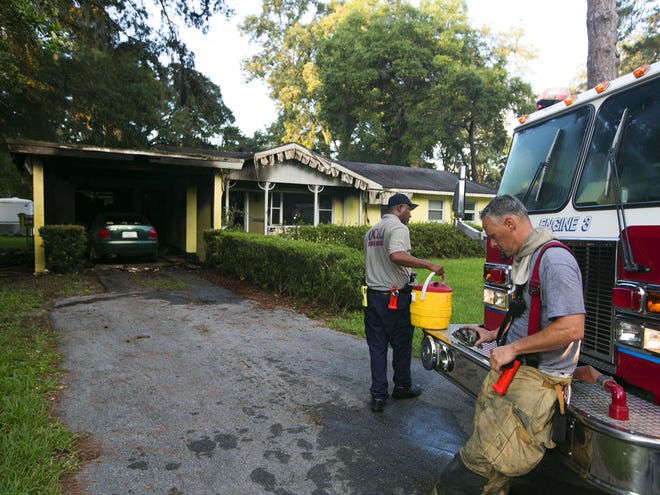 Ocala Fire-Rescue Capt. Mike Magee looks over a melted fire alarm that was working when firefighters arrived at the house fire at 848 Southeast 24th Street in Ocala, FL on Monday July 30, 2012. Neighbors woke the family up as did a working smoke alarm allowing the family, including three children, to escape out the back. There was heavy damage to the home, one firefighter was taken to a local hospital with a medical condition.