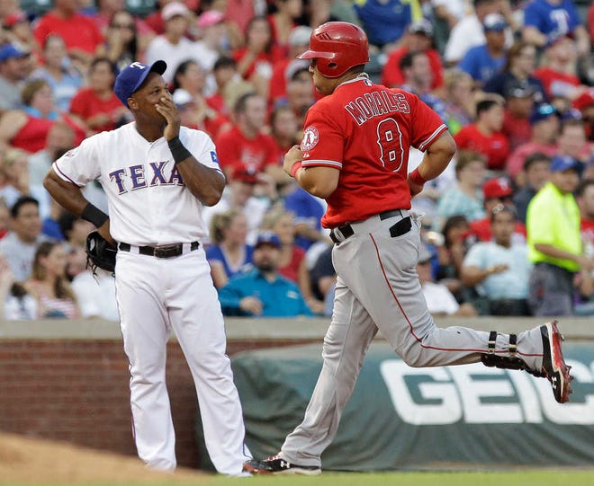 The Angels' designated hitter Kendrys Morales rounds the bases after his grand slam homer with Texas third baseman Adrian Beltre looking on Monday in Arlington. The Angels beat the Rangers, 15-8.