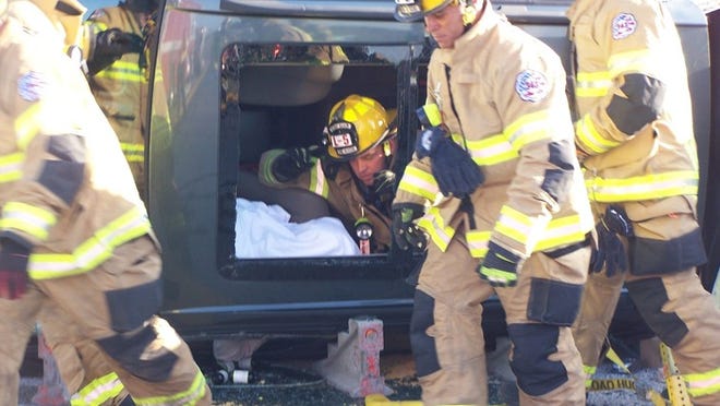 Paramedics treat the driver while she's being extricated (Delray Beach Fire Rescue).