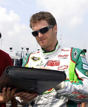 Mel Evans Associated Press Dale Earnhardt Jr. signs autographs as he walks in the in the garage area during Friday's practice for Sunday's Sprint Cup race at Pocono Raceway.