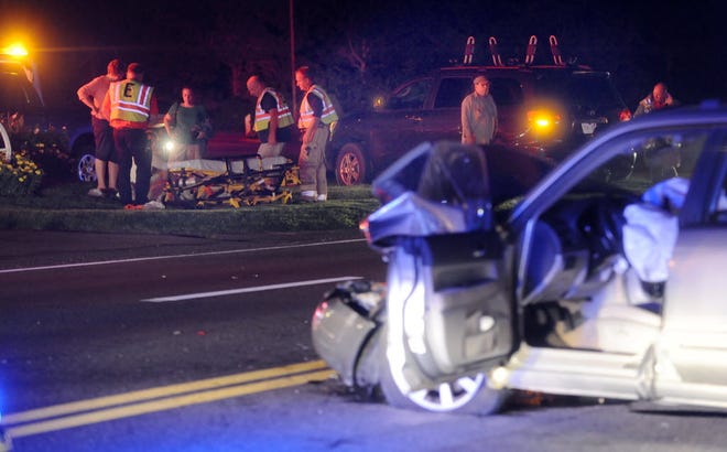 Emergency personnel prepare to transport one of the victims of a multiple-injury accident on Route 6 in front of Red Barn Pizzaria in Eastham Friday evening. The car in the foreground collided with the SUV in the background.