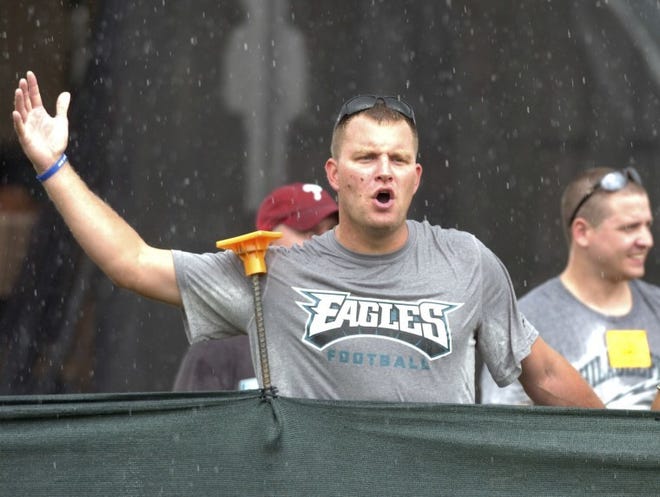 A Philadelphia Eagles fan boos as the team jogs off the field after lightning forced NFL football training camp to be moved indoors, Saturday, Aug. 4, 2012, in Bethlehem, Pa. (AP Photo/The Express-Times, Stephen Flood)