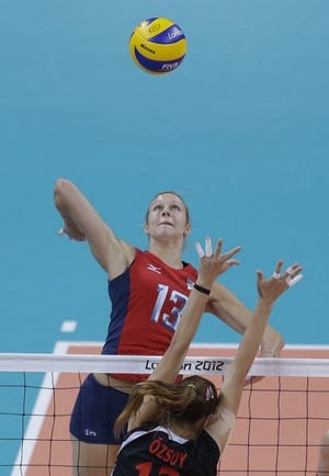 United States' Christa Harmotto, top, prepares to spike over Turkey's Neriman Ozsoy during a women's preliminary volleyball match at the 2012 Summer Olympics, Sunday, Aug. 5, 2012, in London. (AP Photo/Jeff Roberson)