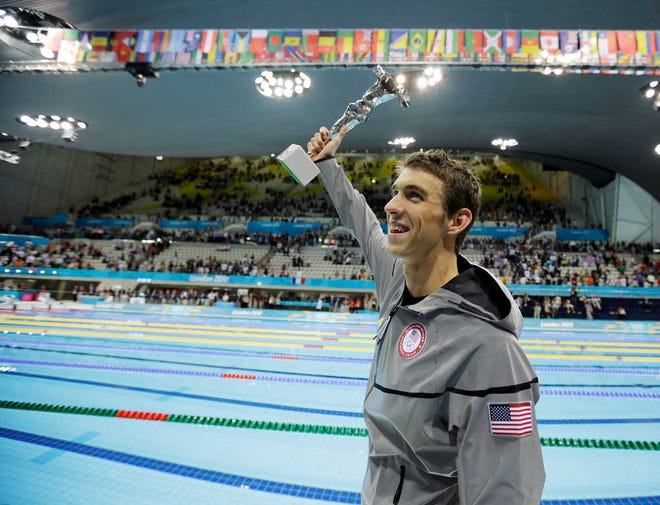United States' swimmer Michael Phelps holds up a silver trophy after being honored as the most decorated Olympian on Saturday at the Aquatics Centre in the Olympic Park during the 2012 Summer Olympics in London.