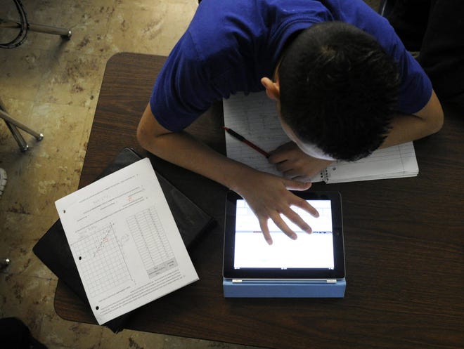A middle school student in Grant, Colo., uses an iPad to work out an algebra problem. The Sandwich School District purchased iPad 3s for all high school freshmen and sophomores.
