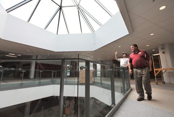 Newark High School maintenance man Chuck Lawrence, left, and district Superintendent Doug Ute look over the rotunda area of the newly built section of the high school. A two-year, $39 million face-lift of the school is nearly complete.