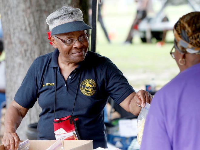 Maxine Bethea hands out popcorn during the Citizens' Academy Block Party as part of the National Night Out Against Crime on Tuesday in Gainesville.
