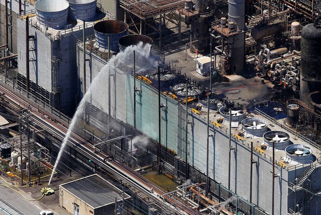 Firefighting crews continue to pour water Tuesday onto a unit after a fire at a Chevron refinery in Richmond, Calif. The fire, which sent plumes of black smoke over the San Francisco Bay area, erupted Monday evening about 10 miles northeast of San Francisco.