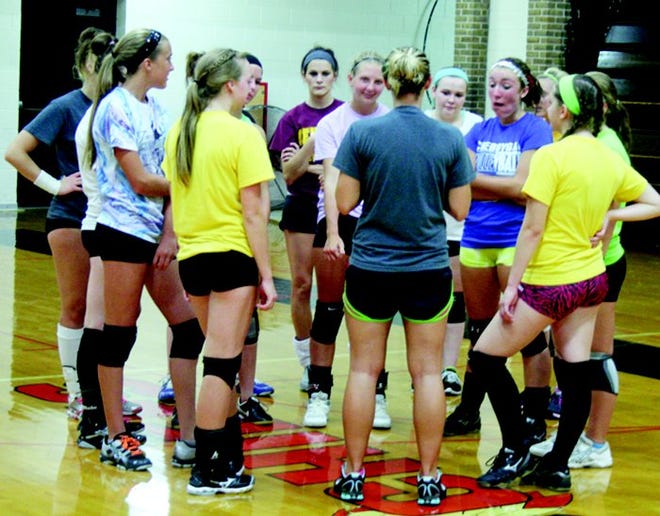 TOP:?Cheboygan volleyball players huddle up during the first day of team tryouts held at Cheboygan High School on Wednesday. BOTTOM RIGHT:?Cheboygan senior Abby Ackerman gets ready during a hitting drill.