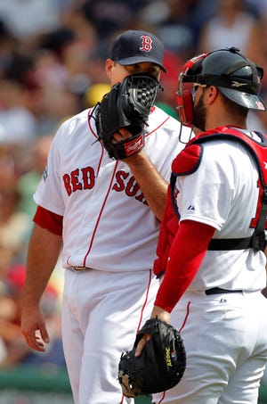 Red Sox pitcher Josh Beckett (left) speaks with catcher Kelly Shoppach after Beckett struggled in the third inning of yesterday's loss to the Rangers.