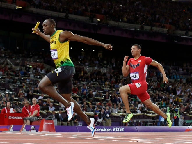 Jamaica's Usain Bolt, left, crosses the finish line ahead of Ryan Bailey of the United States in the men's 4x100-meter relay final during the athletics in the Olympic Stadium at the 2012 Summer Olympics, London on Saturday. Jamaica set a new world record with a time of 36.84 seconds. (The Associated Press)