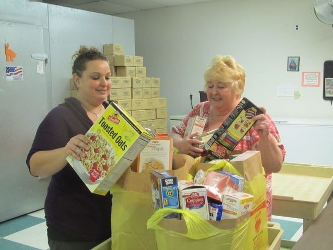 Packaging food at the Catholic Charities Emergency and Community Center in Delanco are case managers Ashley VonGrossen (left) and Gail Jones. An estimated 250,000 seniors in New Jersey do not have enough income to cover their basic needs including food.