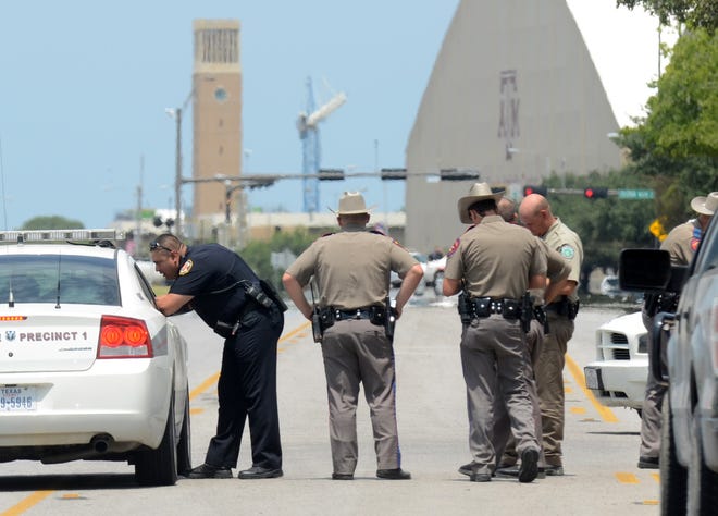 Texas State troopers and Brazos Valley lawmen work the scene of the shooting of two fellow law officers, Monday, Aug. 13, 2012 in College Station, Texas. Police say at least one law enforcement officer and one civilian have been killed in a shooting near Texas A&M University's campus. Assistant Chief Scott McCollum says the gunman also was shot Monday before being taken into custody.