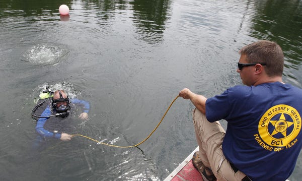 Gary Wilgus helps pull in diver Ed Staley during a training exercise by the Bureau of Criminal         Investigation's new dive team at the Circleville Twin Quarries.