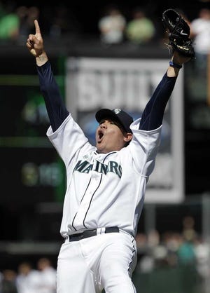 Mariners pitcher Felix Hernandez raises his arms to celebrate throwing a perfect game against the Rays on Wednesday in Seattle.  Ted S. Warren Associated Press