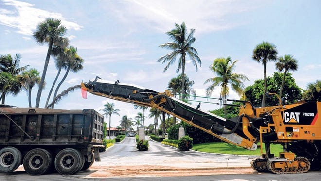 J.W. Cheatham employees remove asphalt from South Ocean Boulevard Wednesday. West Palm Beach has agreed to reimburse the town for removal of an uncharted water pipe.