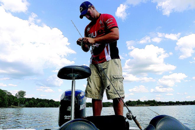 Andrew Henton changes lures while fishing on Lake Springfield. He fishes for the Southern Illinois University at Edwardsville bass fishing club.