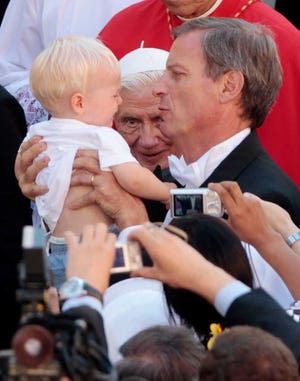 A baby is handed to Pope Benedict XVI, center rear, for his blessing at the end of a mass in San Tommaso da Villanova's church, at his summer residence of Castel Gandolfo, in the outskirts of Rome, Wedensday, Aug. 15, 2012. (AP Photo/Gregorio Borgia)