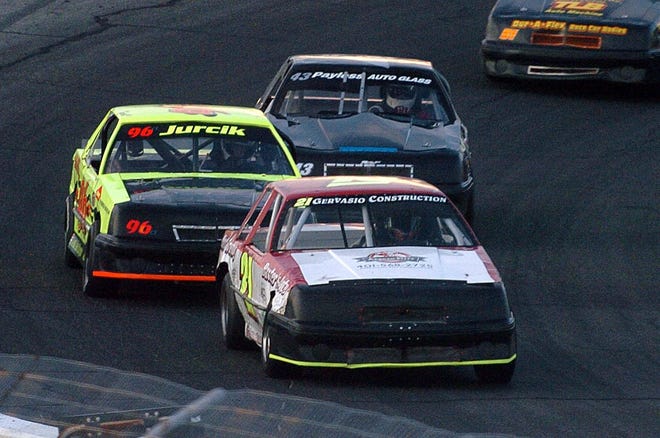Chad Baxter, of Pascoag, R.I., leads Travis Jurcik, of Chaplin, left, and Steve Violette, of Canterbury, on Thursday during the Mini Stocks event at Thompson Speedway. Baxter won the race.