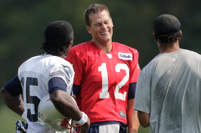 Patriots quarterback Tom Brady (12) talks with teammates during the team's practice on Friday in Foxboro.