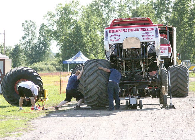 Members of the Mongoose Pro Monster Truck crew put tires on their racing truck Friday night in preparation for the Bad Azz Truck Expo at the Ionia Free?Fairgrounds.