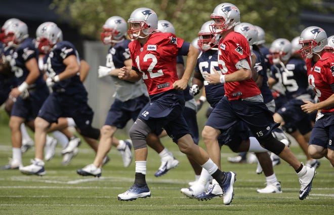 New England Patriots quarterback Tom Brady, center, runs with teammates during training camp in Foxboro.