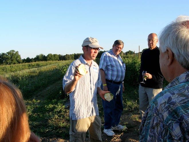 Jon Hunt talks with guests about some of the locally-grown produce at the Hunt Country Twilight Picnic Aug. 18.