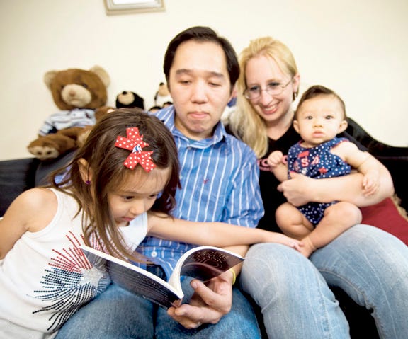 Eddy Eddyto and his wife, Cherie, read to their children Jadealyn, 4, and Gabriella, 7 months, Tuesday in their Pekin home.